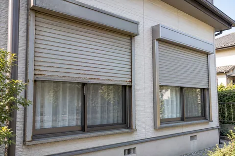 修理か交換か迷っている、住宅の古い窓シャッターと新しい窓シャッター（イメージ）