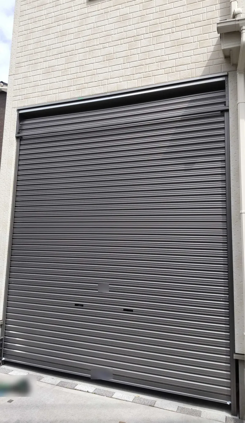 八王子市の戸建て住宅のビルトインガレージに新設した、ガンメタリック色の軽量手動シャッター（閉めた状態）
