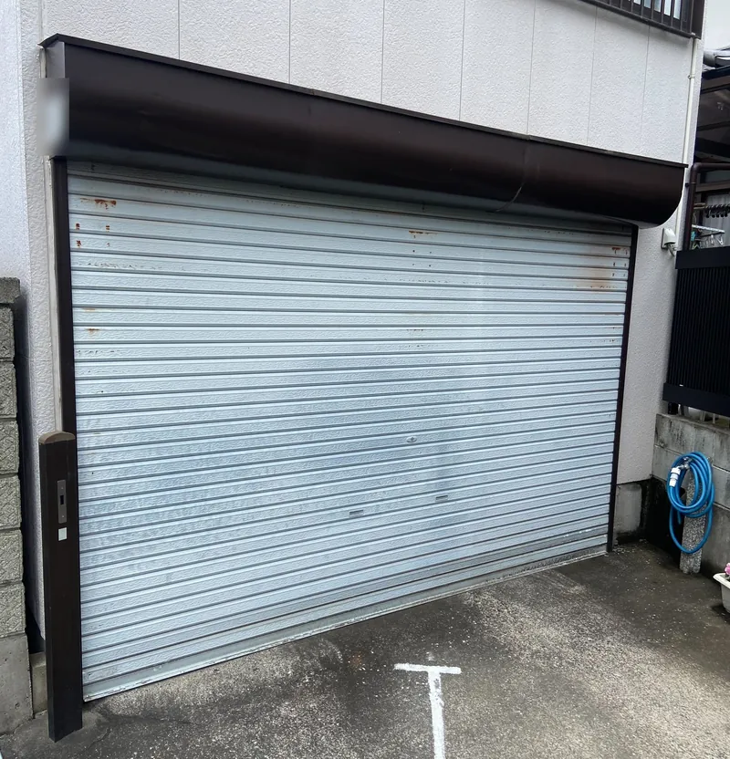 青梅市の住宅ガレージで、重くなっていた交換前の手動シャッター（閉めた状態）