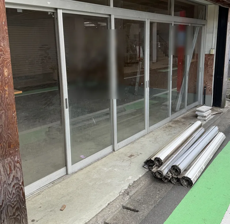 世田谷区の空き店舗で、シャッターのスラットを撤去したあとの店舗の正面と、巻き取った撤去スラット