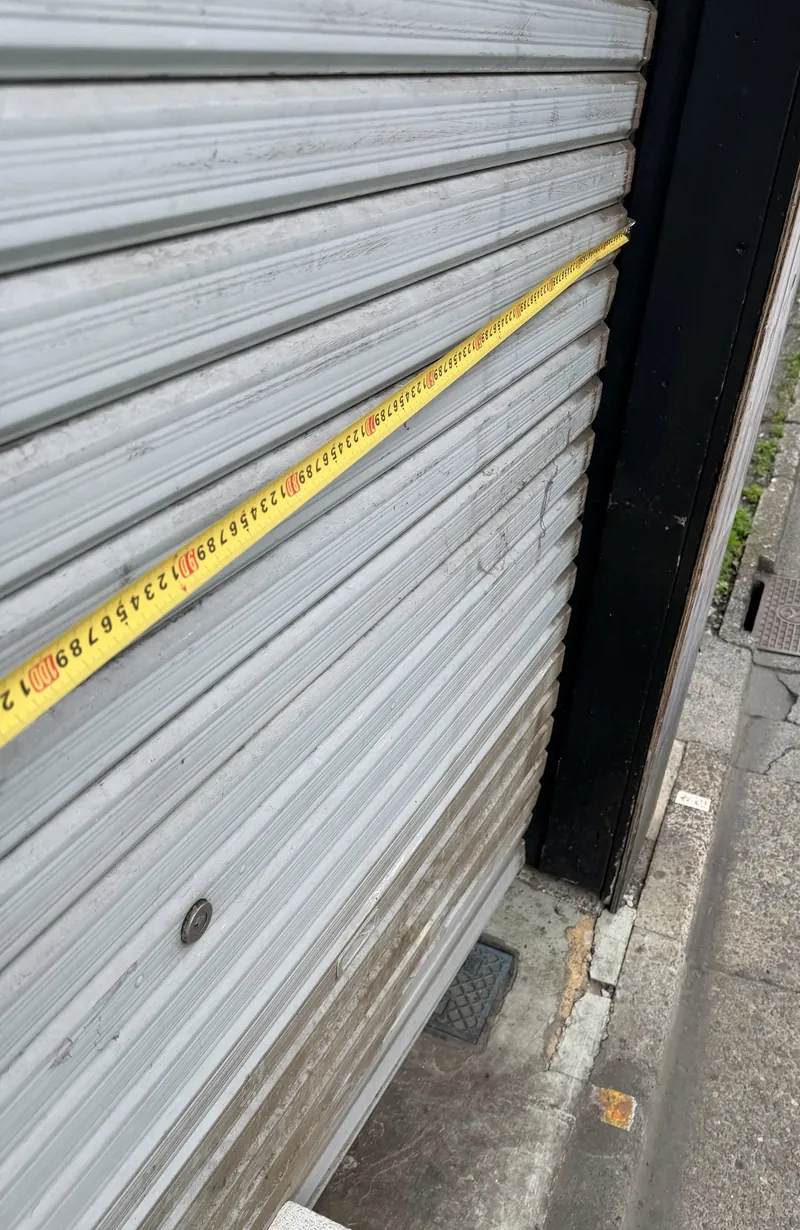 世田谷区の空き店舗で、閉まったまま動かなくなっていた手動シャッターを測っているところ