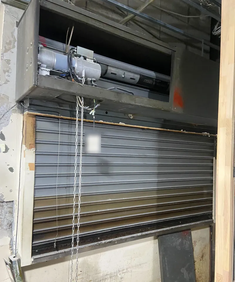 品川区の商業施設テナントで、移設工事の際に開閉機と巻き取り部を開けた防火シャッター