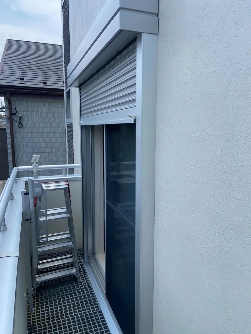 杉並区の住宅で、2階ベランダの窓に取り付けた電動窓シャッター（開けた状態）